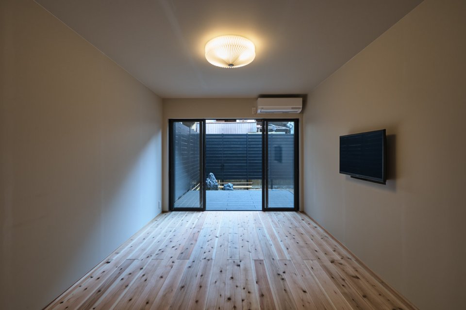 西七条の宿の木の床の居室。庭に面した開口部がある