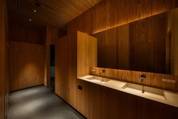 91°SAUNA 東京都 サウナ 木×間接照明・サウナ室の段床 洗面カウンター。木の壁と間接照明（サンリット建設（DESIGN STUDIO TEMPO））