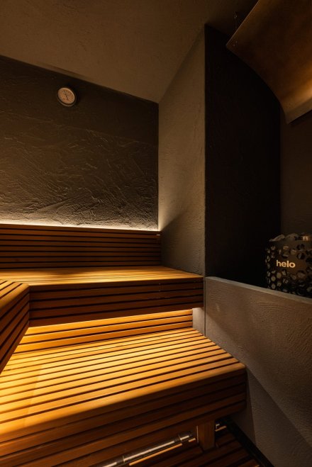 91°SAUNA private 東京都 サウナ 木×黒・個室サウナ 個室サウナ室。木の段床と間接照明、黒い壁（サンリット建設（DESIGN STUDIO TEMPO））