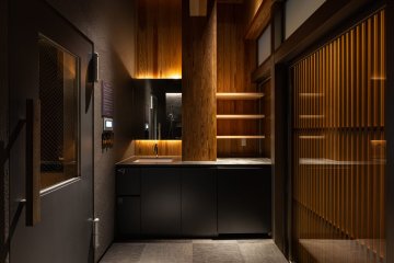 91°SAUNA private 東京都 サウナ 木×黒・個室サウナ 個室の入口まわり。黒のキッチンカウンターと木の格子（サンリット建設（DESIGN STUDIO TEMPO））