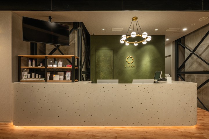 LIKKA SKINCLINIC｜受付背面の棚と照明（サンリット建設・likkaスキンクリニック）