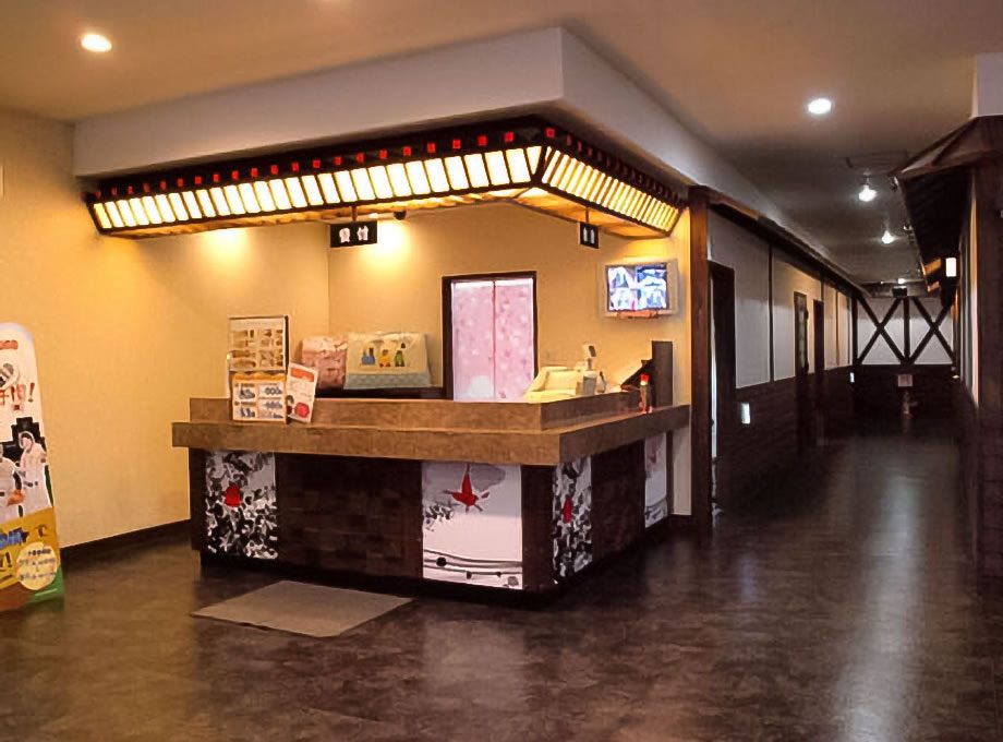 カラオケ歌屋 北見緑町店：照明と壁面を整えた受付。施工：タカハシアートプランニング株式会社
