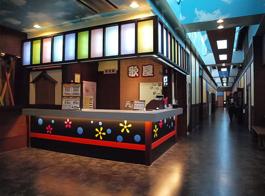 カラオケ歌屋 輪西店：色を取り入れた受付と廊下。施工：タカハシアートプランニング株式会社
