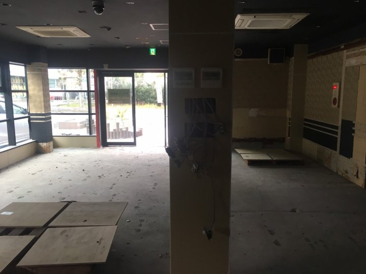 つつじ薬局 土気店（千葉県千葉市緑区）の着工前。前テナント解体後のコンクリート床とガラスの入口（施工：株式会社ビリーフデザイン）