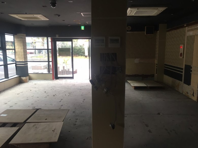 つつじ薬局 土気店（千葉県千葉市緑区）の着工前。前テナント解体後のコンクリート床とガラスの入口（施工：株式会社ビリーフデザイン）