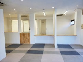 つつじ薬局 土気店（千葉県千葉市緑区）の完工時。木の天板のカウンター、柱で区切った窓口、市松のタイル床（施工：株式会社ビリーフデザイン）
