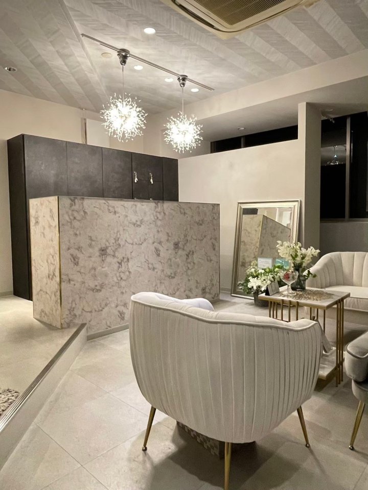Salon de SoLA 三田市 女性専用エステサロンの受付と待合。大理石調の受付カウンターと壁、白いベルベットのソファ、スパークル調のペンダント照明、ミラー（LEBON DESIGN）