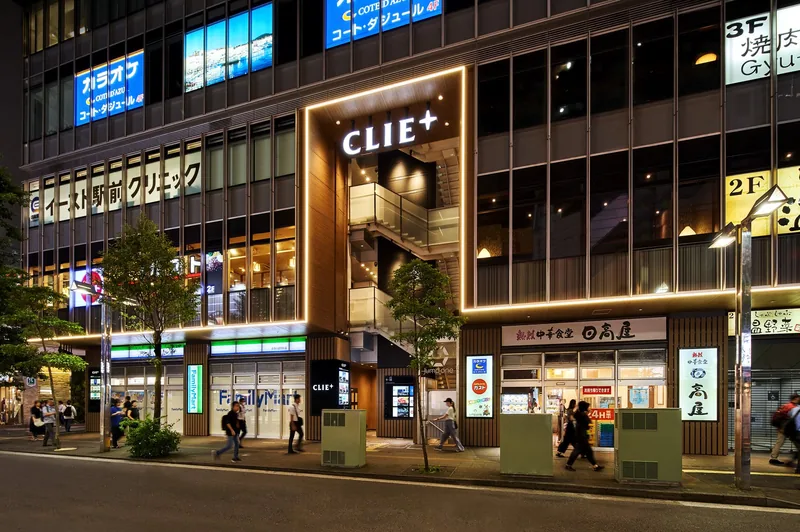 駅前の商業施設の夜の外観。入口のまわりを光のラインで縁取り、施設名CLIE+の大きなサイン(株式会社ノムラアークス)
