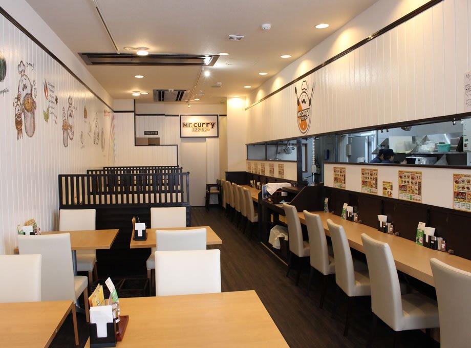 北海道のカレー屋の内装（白壁×木のテーブル席とカウンター・施工：タカハシアートプランニング株式会社）