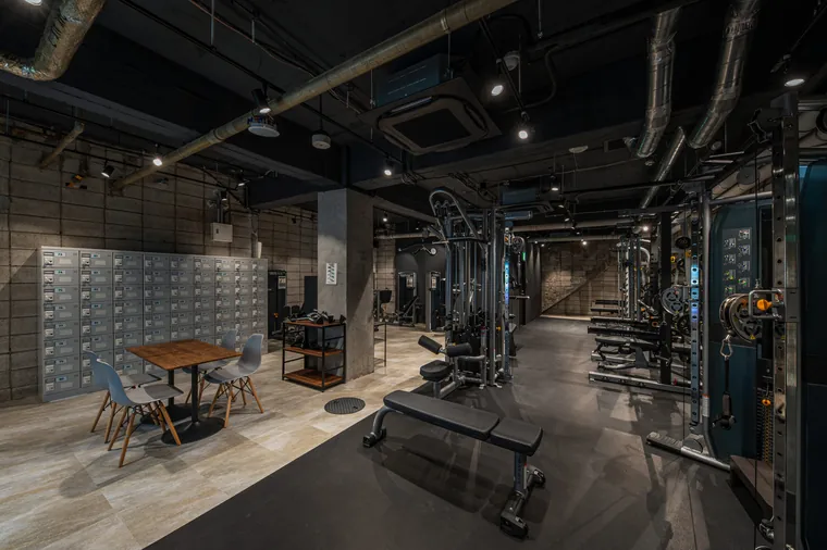RefineFit24 横須賀中央店（横須賀市・フィットネスジム）。マシンの配置とロッカー、テーブル席を見渡せるジムの室内。