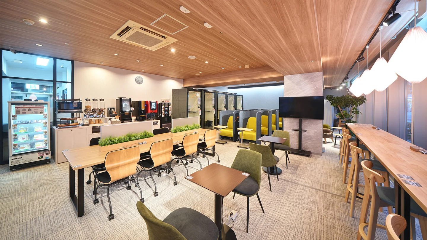 ACCEA CAFÉ 堺筋長堀橋店（大阪府大阪市中央区・コワーキングスペース）。窓に沿うカウンター席と中央のテーブル席を配置しています。椅子の間を通る動線やドリンク設備の位置も見えます。