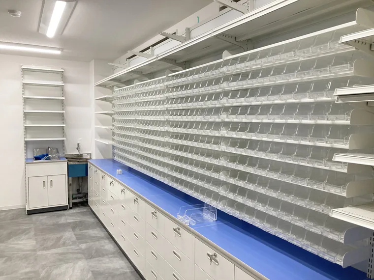 調剤室に棚と収納を設置した完成写真です。薬剤を入れる前の状態で、作業台と水まわりの位置を確認できます。
