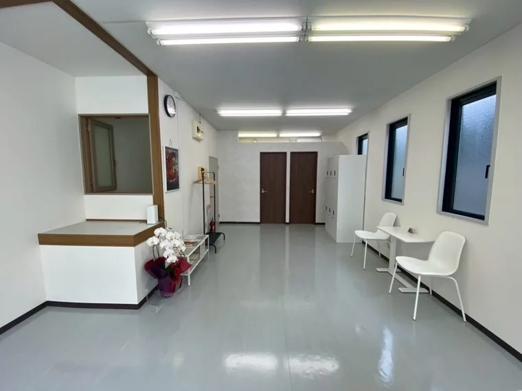 白いカウンターの向かいに待合の椅子を配置。受付から奥の部屋へ通路が続きます。