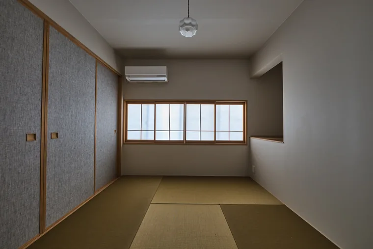 縁のない畳、織物調の建具、格子窓を組み合わせた和室。