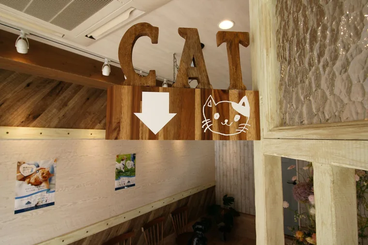 猫の絵と文字のサインで、待合への方向を案内しています。