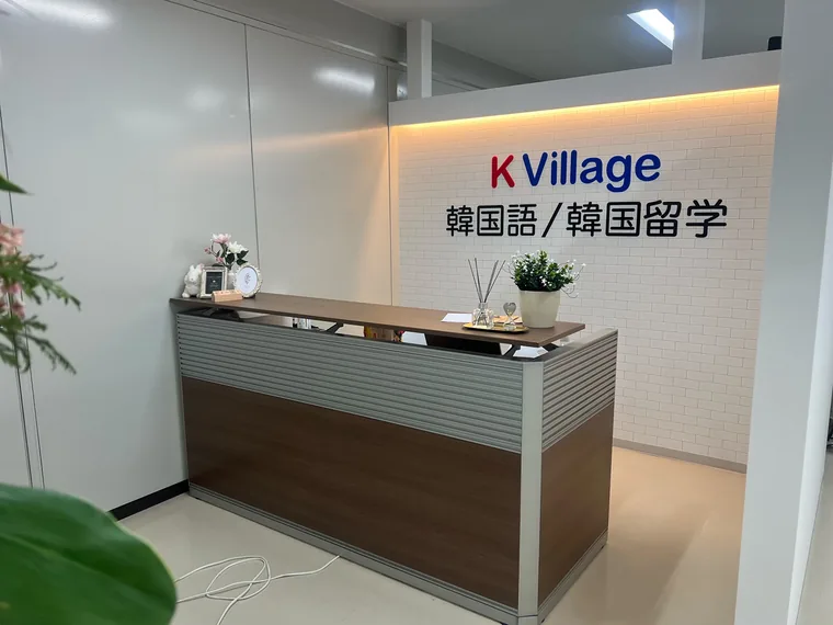 K Village 千葉駅前校の受付です。木目のカウンターの背後に、教室名のサインを設けています。
