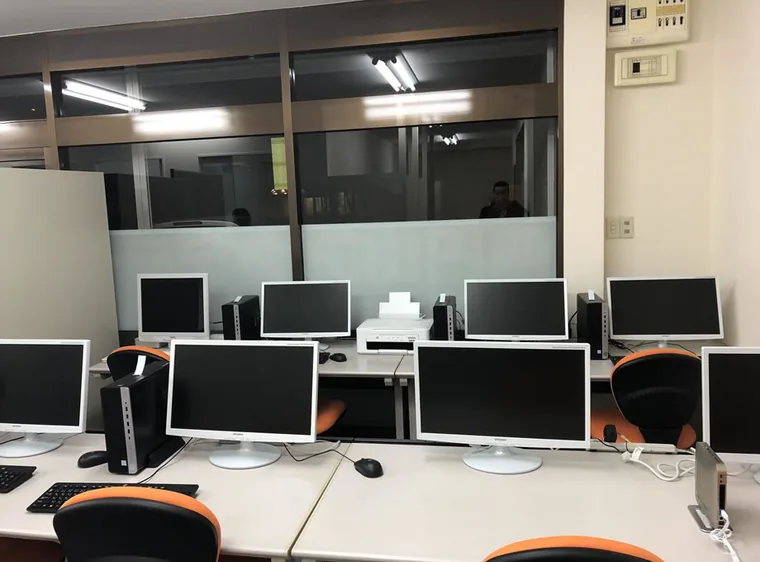 長い机にパソコンと椅子を配置した、円山アカデミーの学習スペースです。