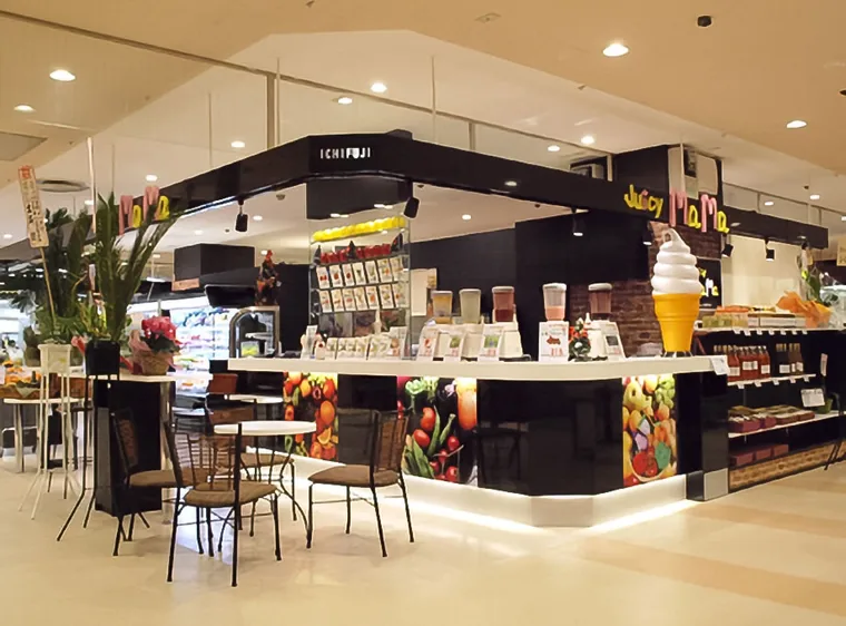 フルーツ・ジュース等を扱う複合店の事例です。カウンターの前にテーブルと椅子を並べ、物販と飲食が一つの区画に収まっています。